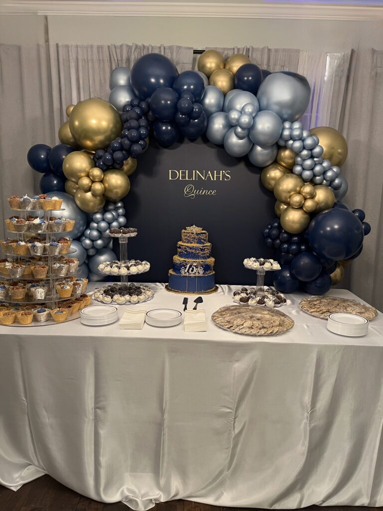 Navy, silver and gold balloon garland arching over a quinceanera dessert table in Austin, TX
